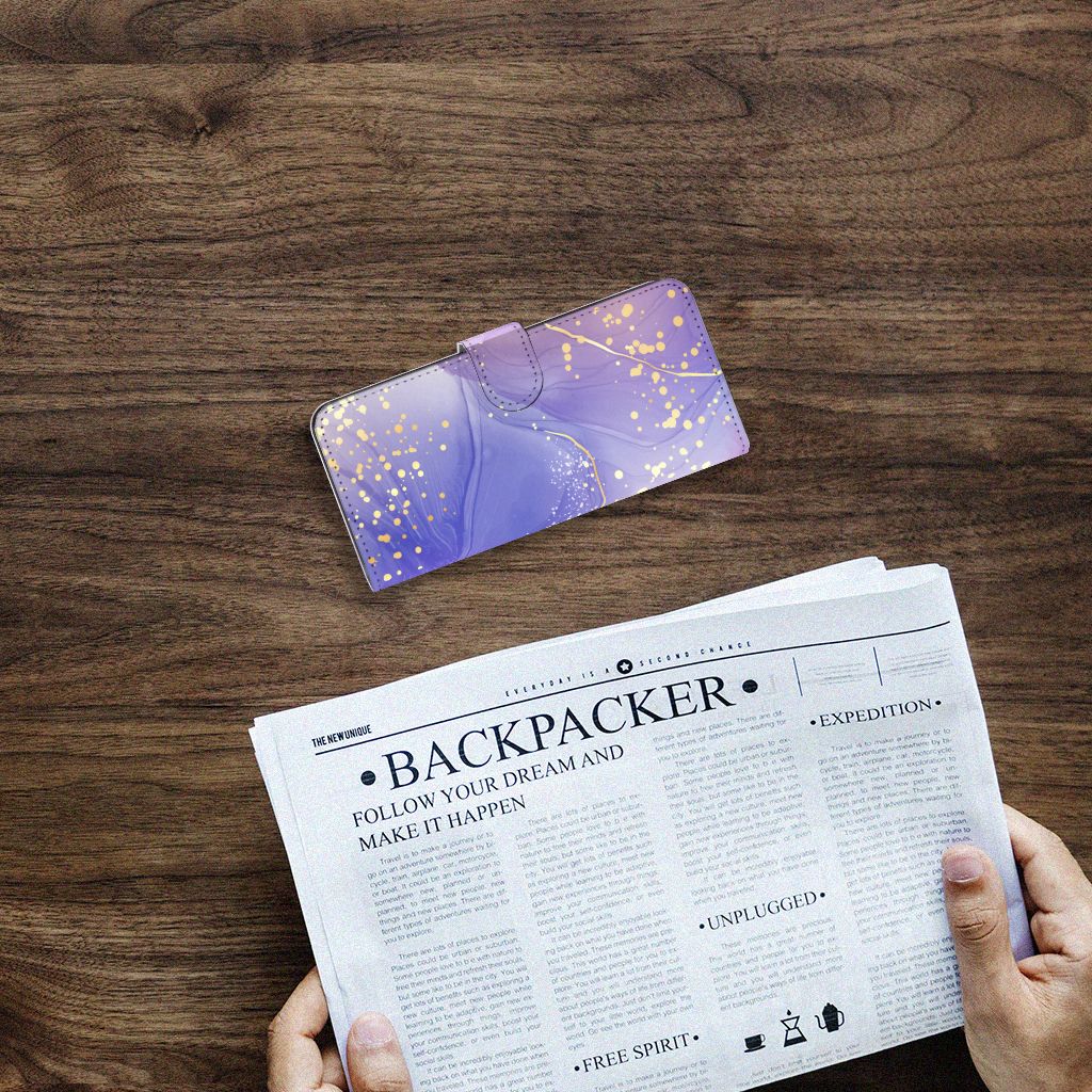 Hoesje voor Samsung Galaxy A14 4G Watercolor Paars op een houten tafel met een krant ernaast.