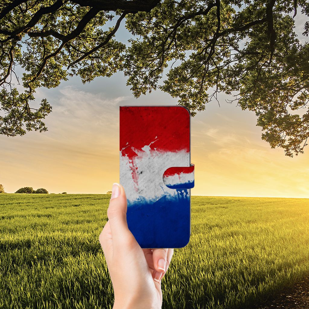 OPPO Reno8 T 5G Bookstyle Case Nederland met Nederlandse vlag in hand met uitzicht op het platteland.