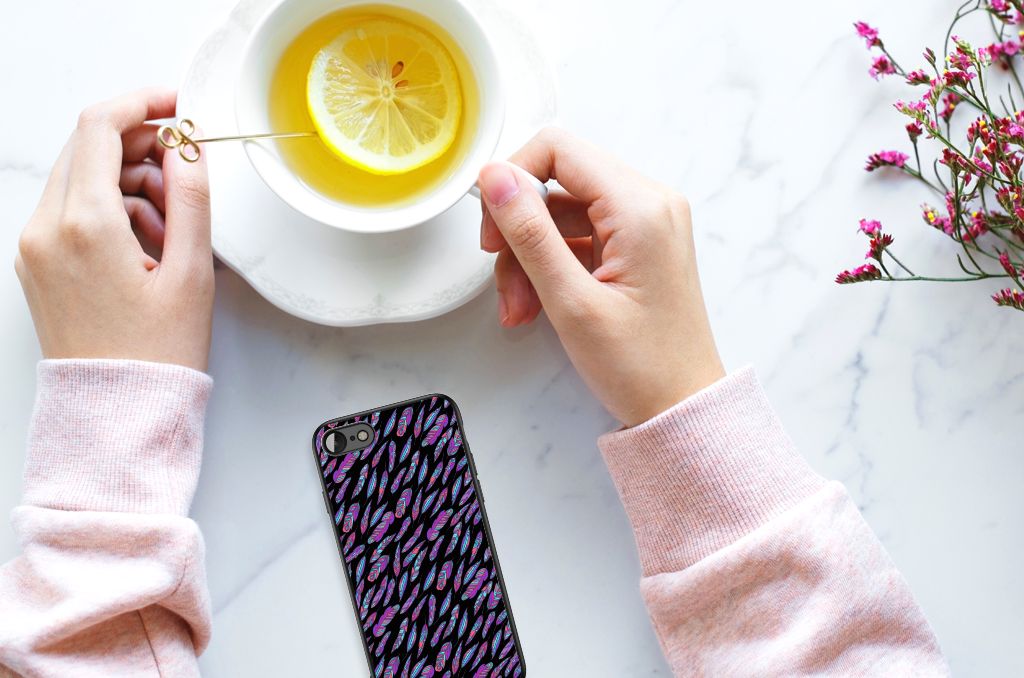 Hand holding a cup of tea next to the iPhone SE 2022 | SE 2020 | 7/8 Back Case Feathers Color on a marble table.