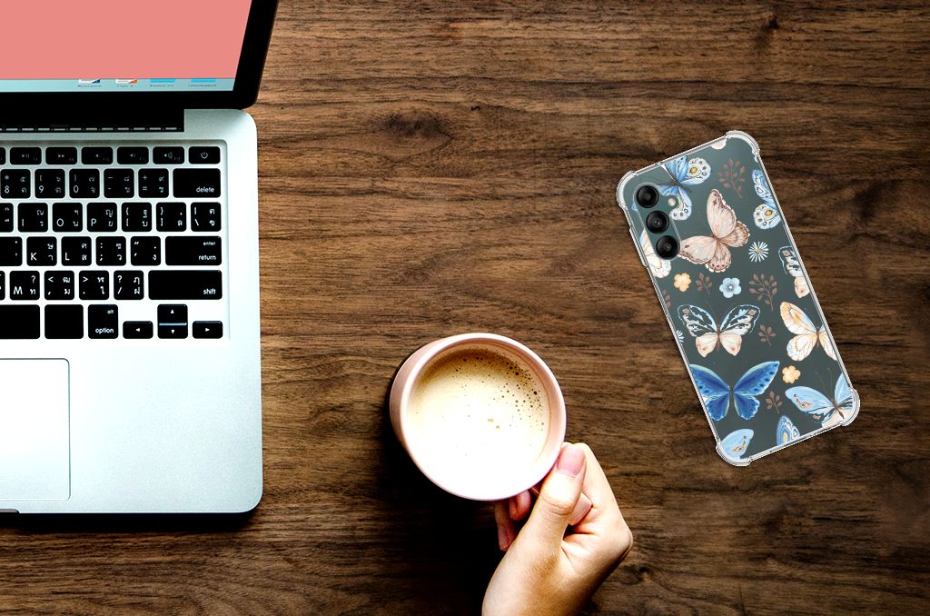 Case Anti-shock voor Samsung Galaxy A14 5G/4G Vlinder naast een laptop en een mok op een houten tafel.