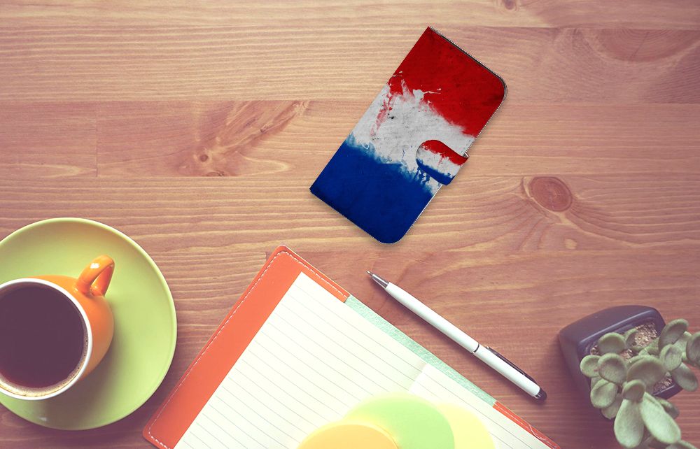 Google Pixel 8 Bookstyle Case Nederland met Nederlandse vlag op een bureau met koffie en notitieboekje.