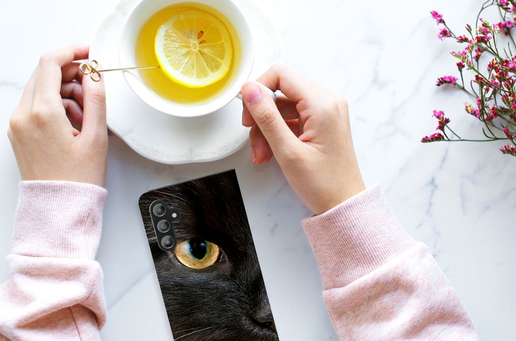 Samsung Galaxy A14 5G Hoesje maken Zwarte Kat op een marmeren tafel met een kopje thee.