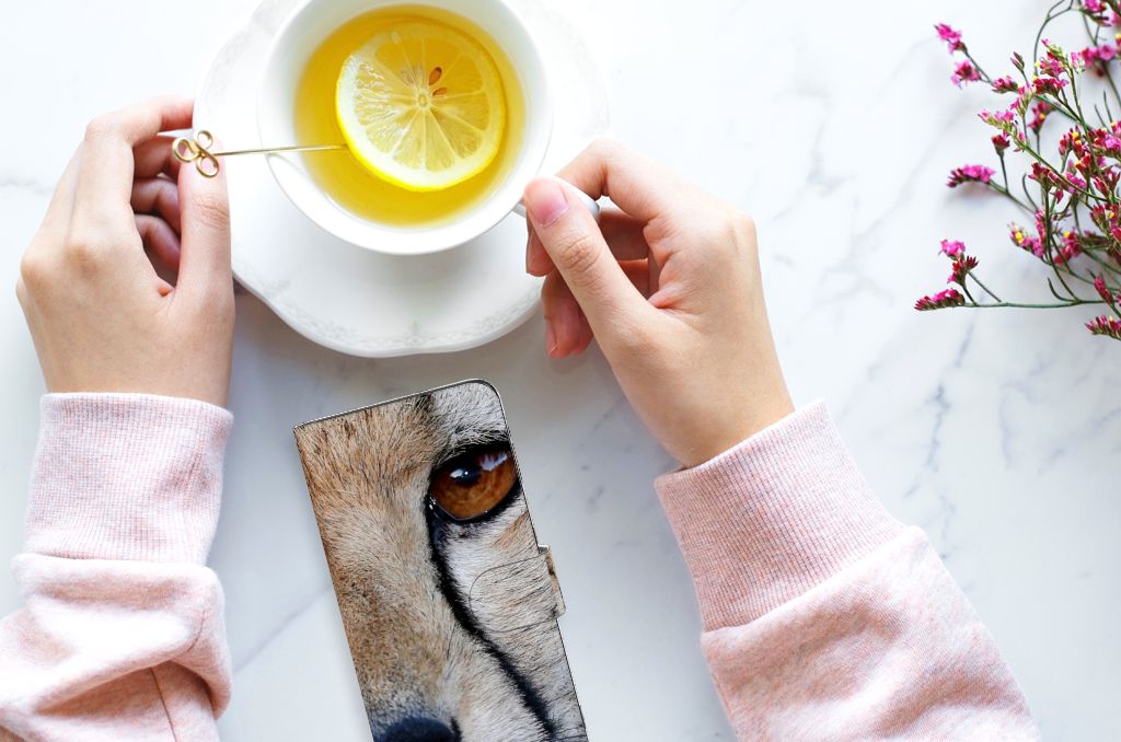 OPPO Find X6 Pro Telefoonhoesje met Pasjes Cheetah en een kopje thee met citroen op een marmeren tafel.