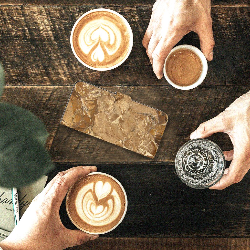 Motorola Moto G52 | Moto G82 Bookcase Marmer Creme op tafel met koffie en water.