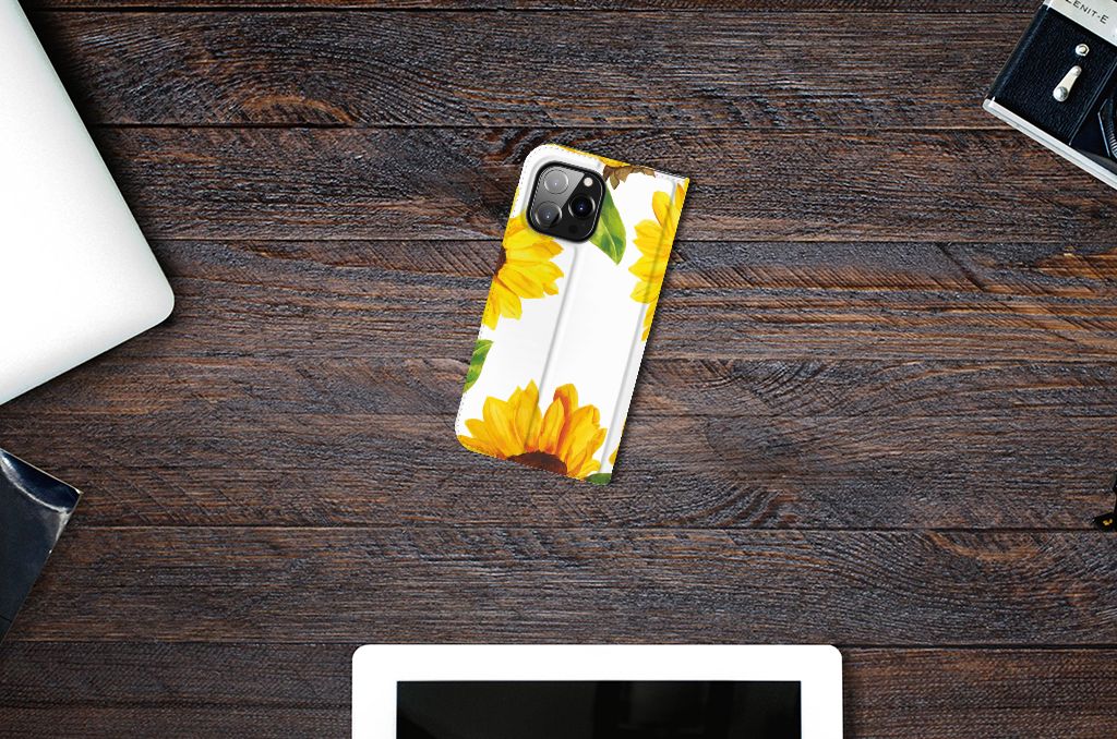 Smart Cover voor iPhone 14 Pro Max Zonnebloemen met een vrolijk zonnebloemen ontwerp op een houten tafel.