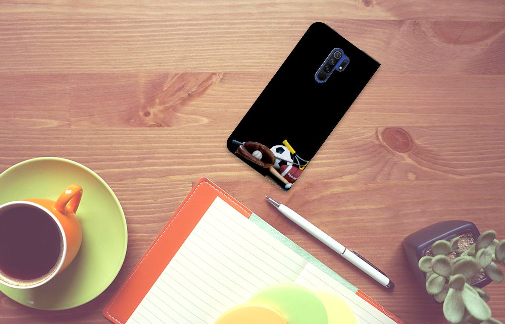 Xiaomi Redmi 9 Hippe Standcase Sports displayed on a wooden desk with a coffee cup and notebook.