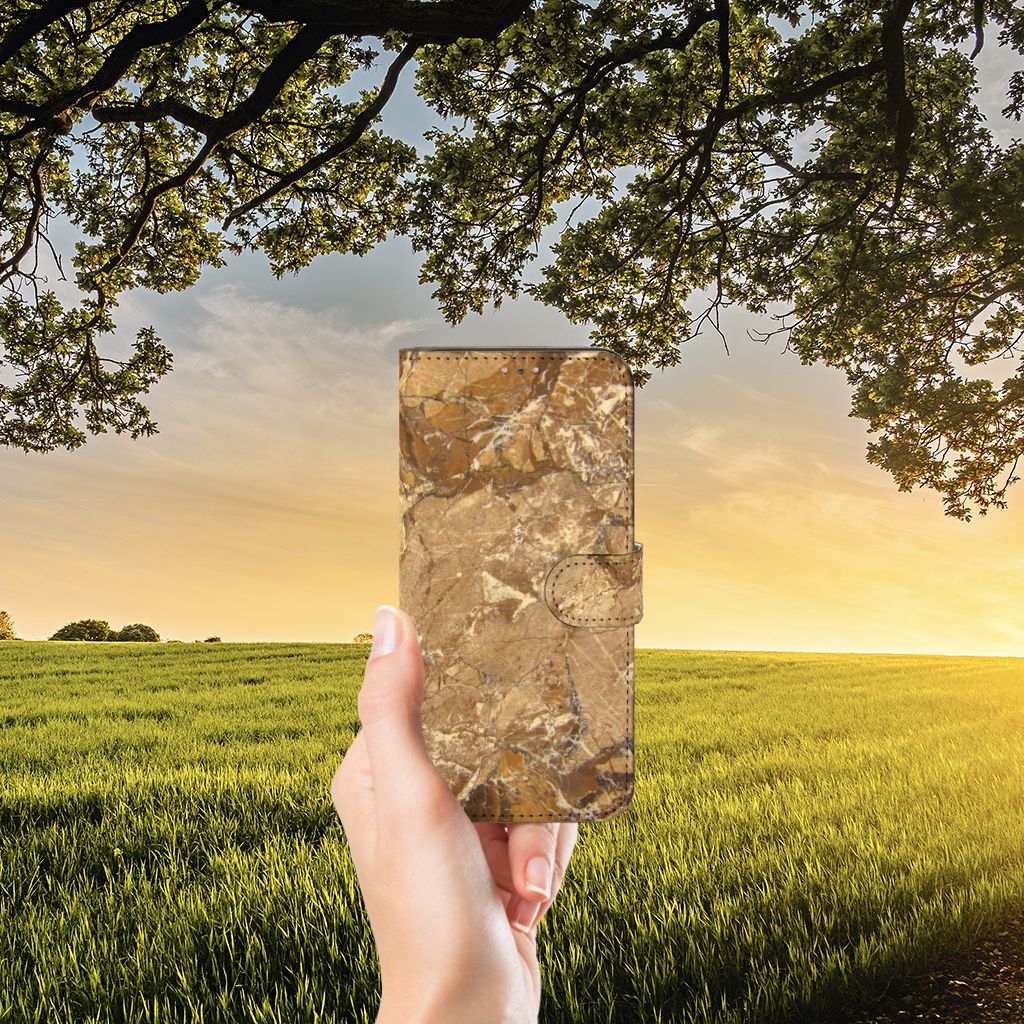 Xiaomi Redmi Note 11 Pro 5G/4G Bookcase Marmer Creme in hand against a scenic sunset backdrop.