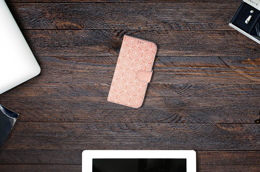 iPhone 14 Pro Telefoon Hoesje Pattern Orange op een houten tafel, naast een laptop en tablet.