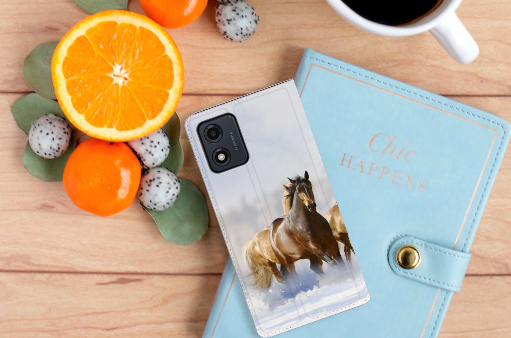 Motorola Moto E13 4G Hoesje maken Paarden met paardenprint op een tafel naast fruit en een boek.
