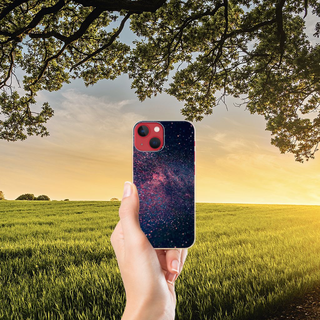 Afbeelding van een hand die het Apple iPhone 13 TPU Hoesje Stars vasthoudt tegen een zonsondergang met sterrenhemel. đ