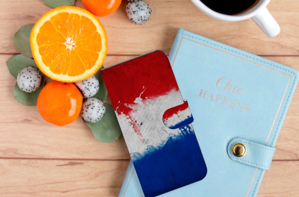 Motorola Moto G62 5G Bookstyle Case Nederland met Nederlandse vlag op een tafel met fruit en een notitieboek.