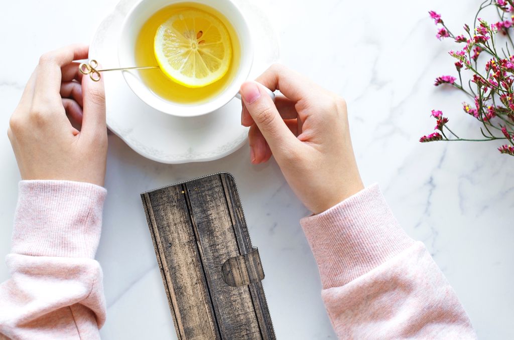 Samsung Galaxy A14 5G Book Style Case Steigerhout naast een kopje thee met citroen op een tafel.