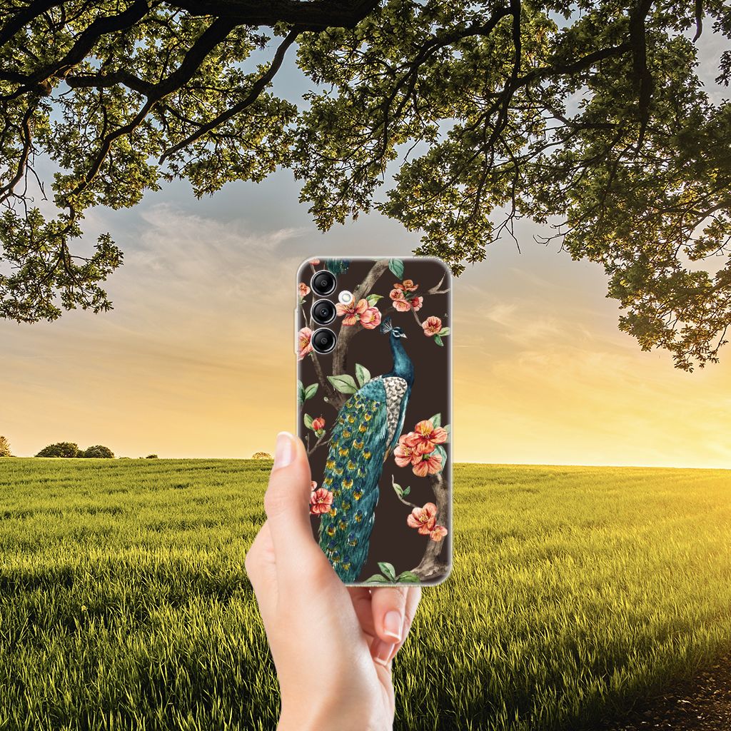 Samsung Galaxy A14 5G TPU Hoesje Pauw met Bloemen in hand, met bloemen en pauwenprint tegen een zonsondergang.