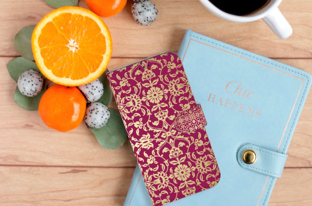 Wallet Case iPhone 14 Plus Barok Pink op een houten tafel met fruit en een planner.