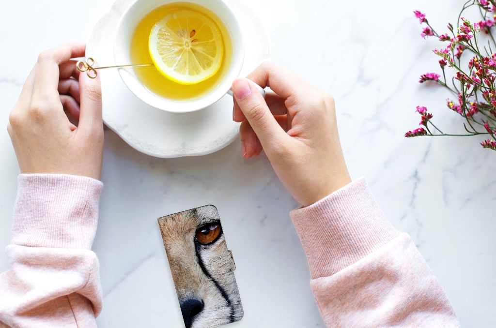 Samsung Galaxy A53 Telefoonhoesje met Pasjes Cheetah naast een kopje thee met citroen en een bloem.