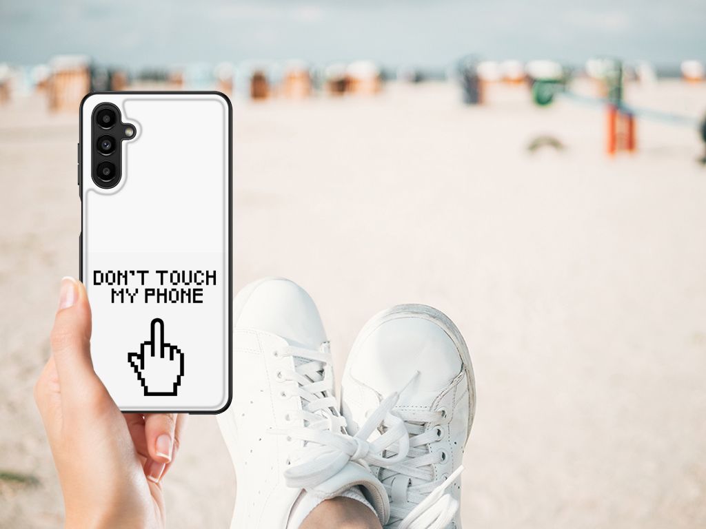 Samsung Galaxy A14 5G Telefoon Hoesje Finger Don't Touch My Phone in hand on beach with white sneakers.