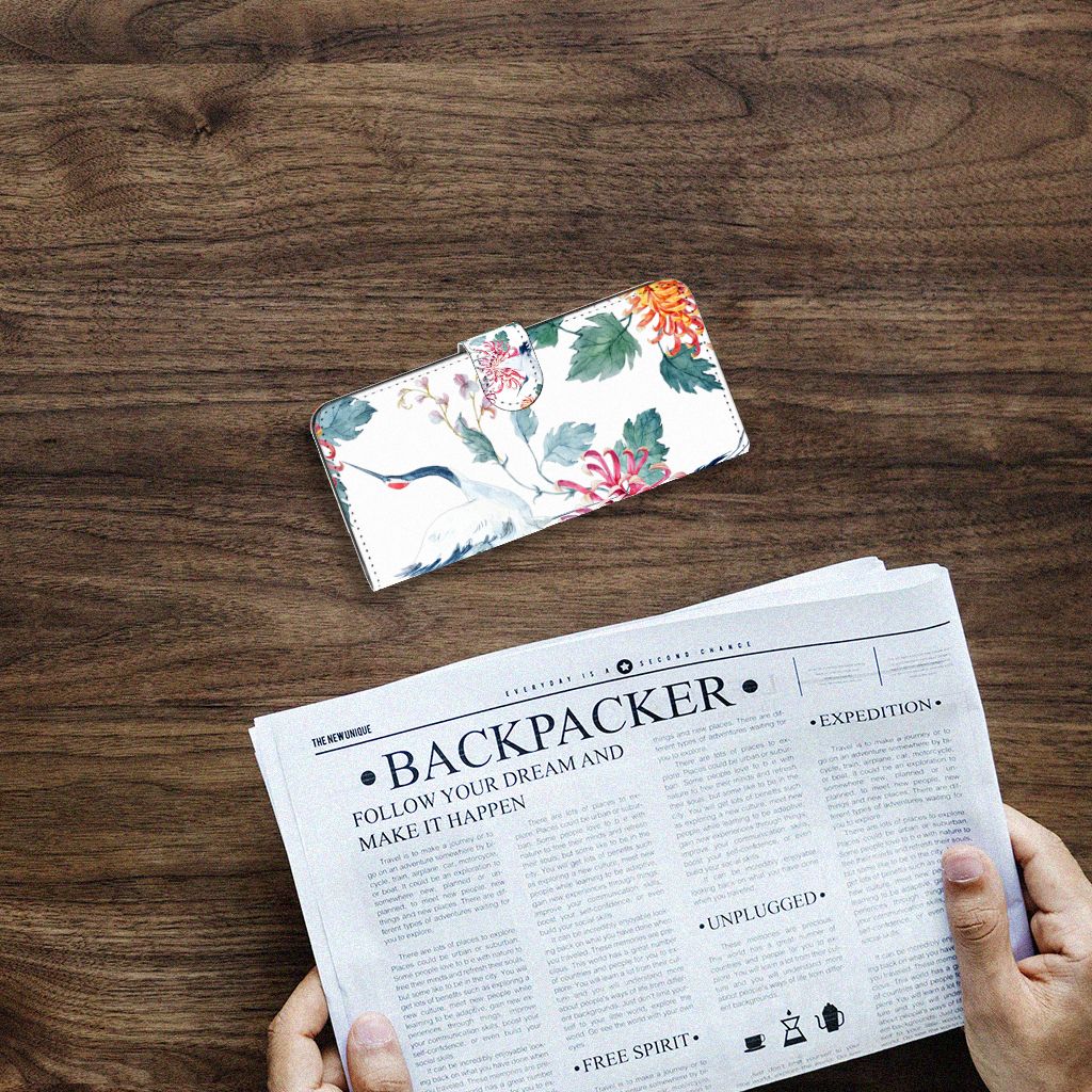 Samsung Galaxy A14 4G Telefoonhoesje met Pasjes Bird Flowers op een houten tafel met een krant eronder.