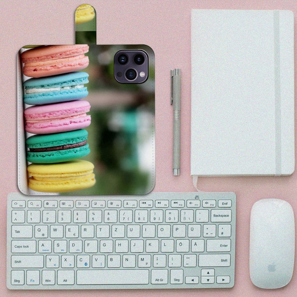 iPhone 15 Pro Max Book Cover Macarons met kleurrijke Franse koekjes op een desk met toetsenbord en notitieboek.