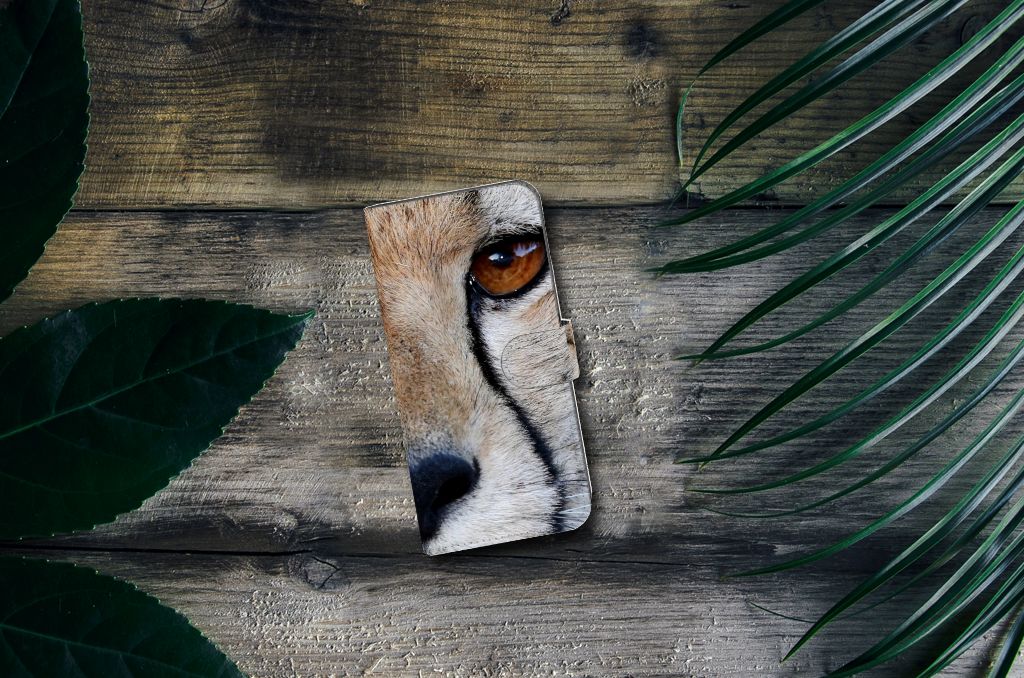 Nokia C12 Telefoonhoesje met Pasjes Cheetah met close-up van cheeta oog op houten achtergrond.