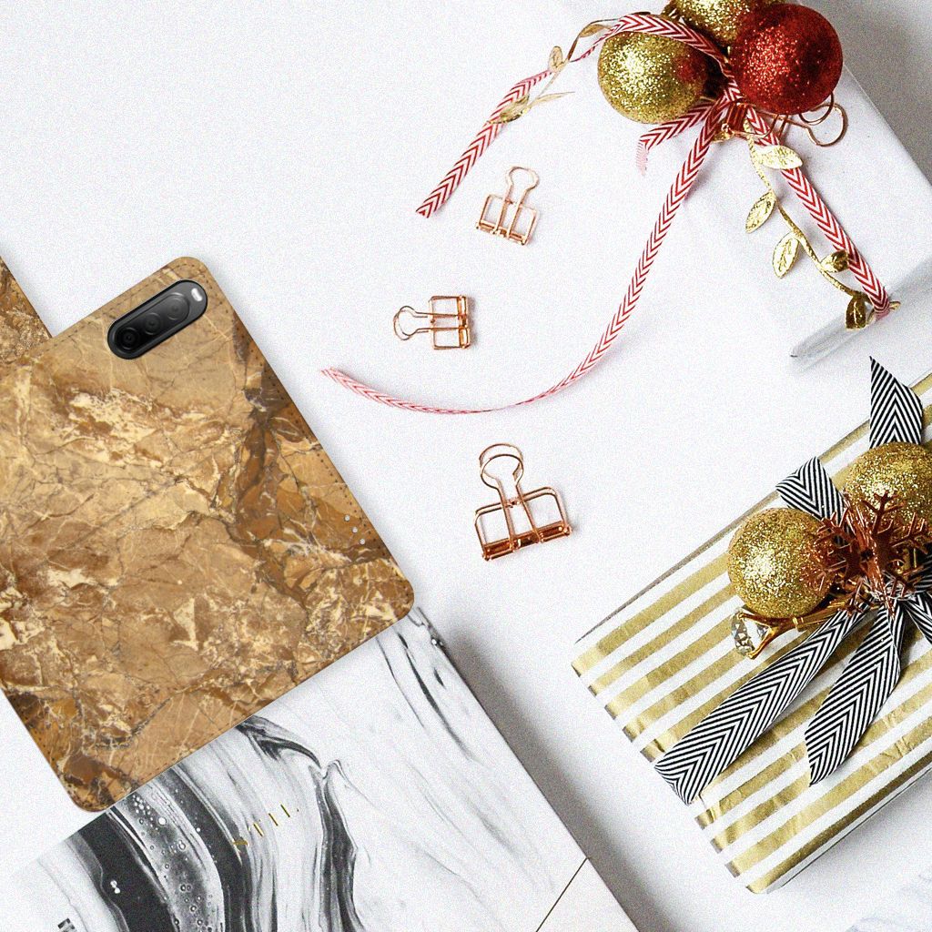 Sony Xperia 10 IV Bookcase Marmer Creme op een tafel met cadeau's en decoraties.