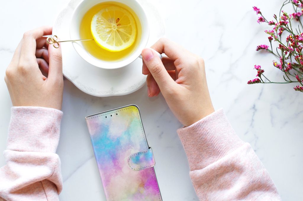 Hoesje Alcatel 1S 2020 Watercolor Light naast een kopje thee met citroen en handen in een roze trui.
