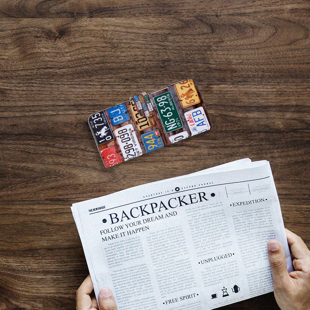 Samsung Galaxy A14 4G Telefoonhoesje met foto Kentekenplaten bovenop een krant op een houten tafel.