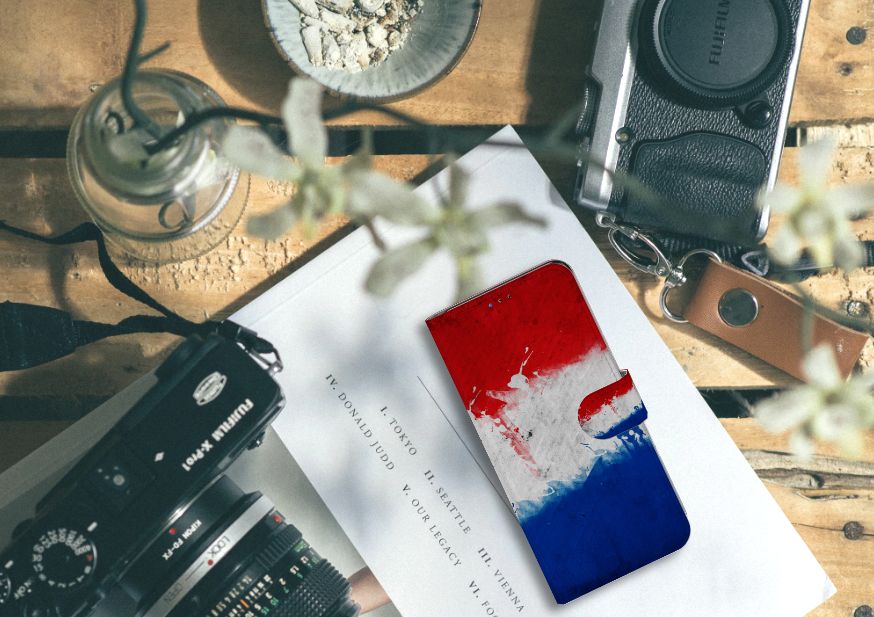Samsung Galaxy A20s Bookstyle Case Nederland met design van de Nederlandse vlag op een tafel naast vintage camera's.