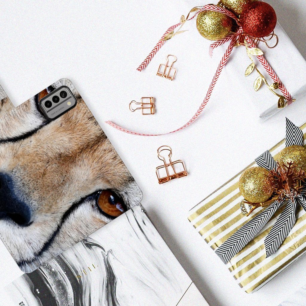Nokia G22 Telefoonhoesje met Pasjes Cheetah met close-up van cheeta op een tafel met cadeaus en decoraties.