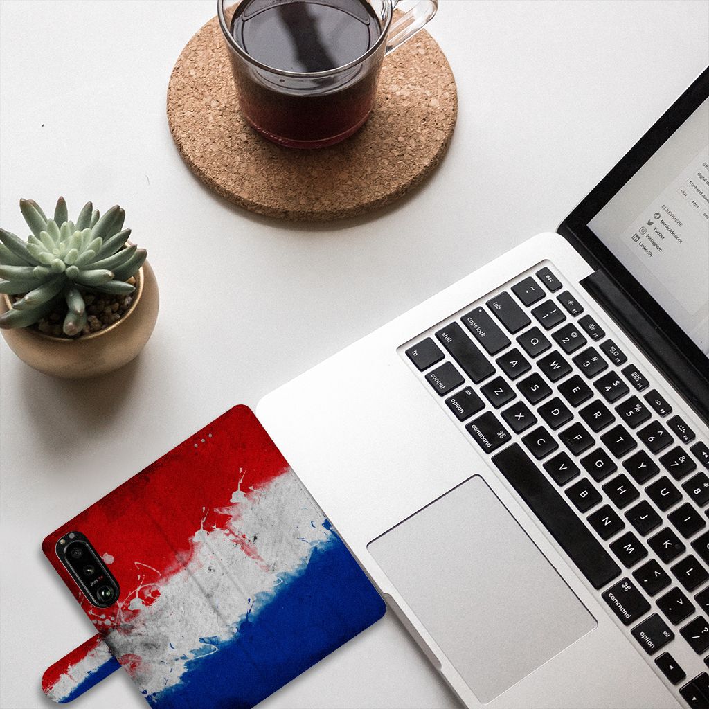 Sony Xperia 5III Bookstyle Case Nederland met design van de Nederlandse vlag, gelegen naast een laptop en koffie.