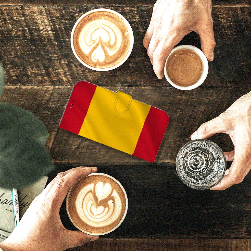 iPhone 14 Pro Max Bookstyle Case Spanje op een tafel met koffie en handen, perfect voor stijl en bescherming.