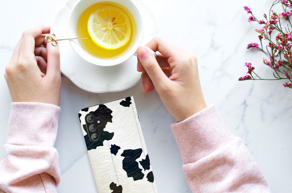 Samsung Galaxy A14 5G Hoesje maken Koeienvlekken op tafel met hand en kop thee met citroen.