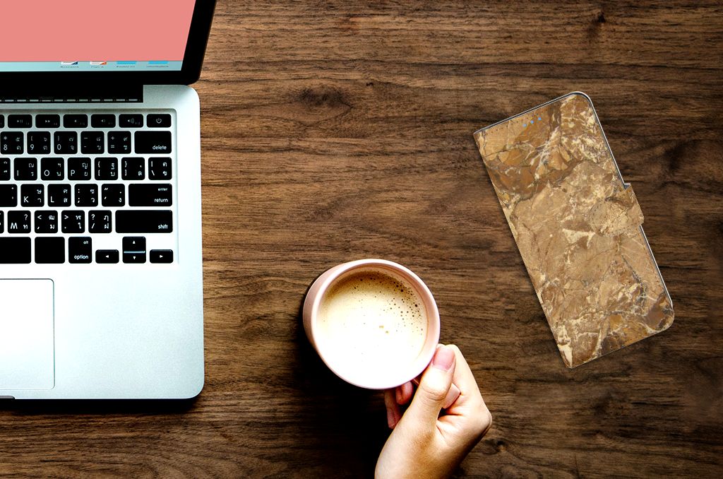 Xiaomi Mi 10T Pro | Mi 10T Bookcase Marmer Creme op een houten tafel naast een laptop en een kop koffie.