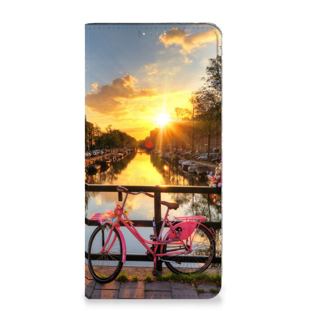 Samsung Galaxy A14 5G Book Cover Amsterdamse Grachten met een roze fiets en zonsondergang boven de grachten.
