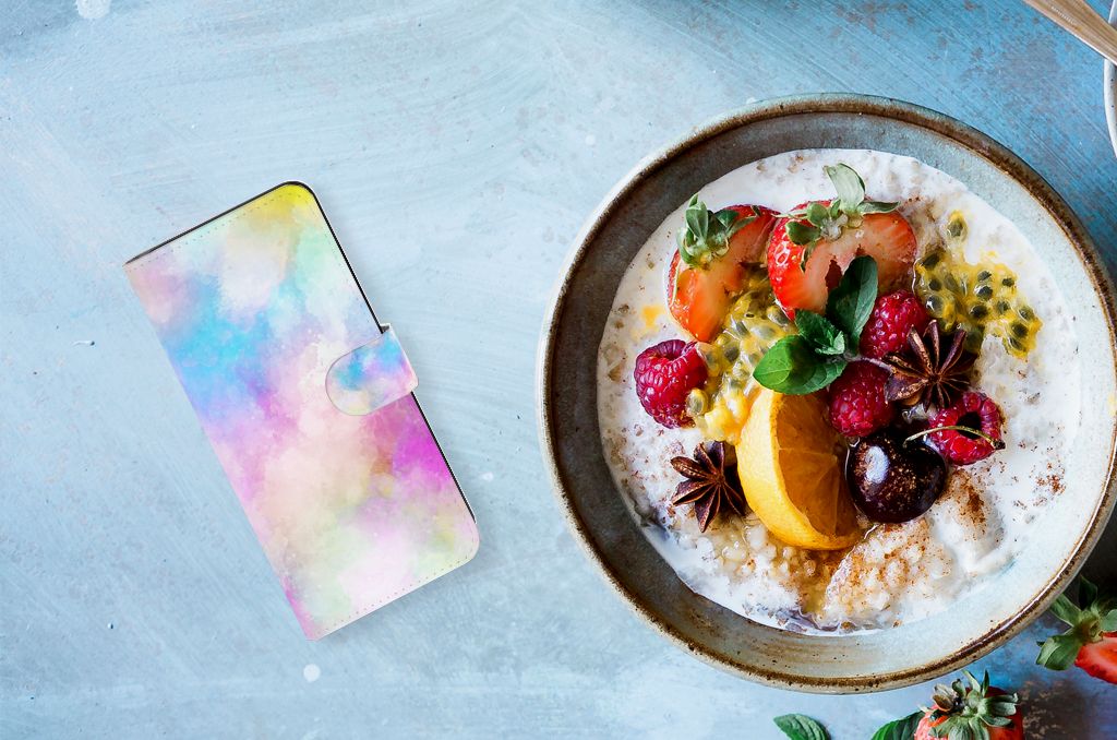 Hoesje Samsung Galaxy M54 Watercolor Light naast een kom ontbijt met fruit en granola.