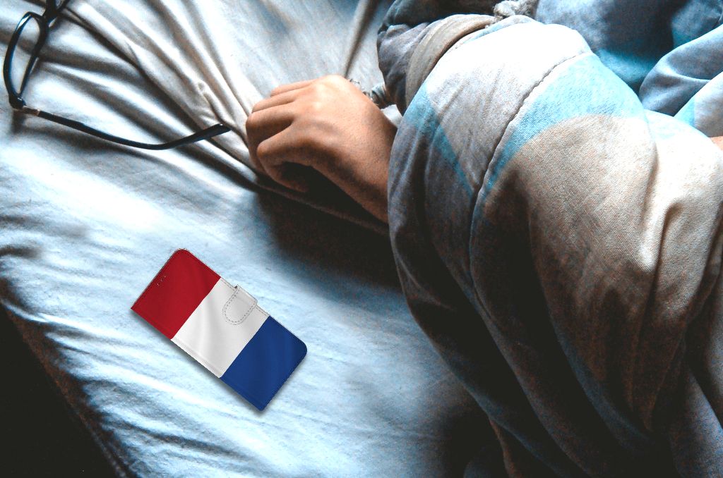 Motorola Moto E7i Power | E7 Power Bookstyle Case Nederlandse Vlag op bed naast een hand.
