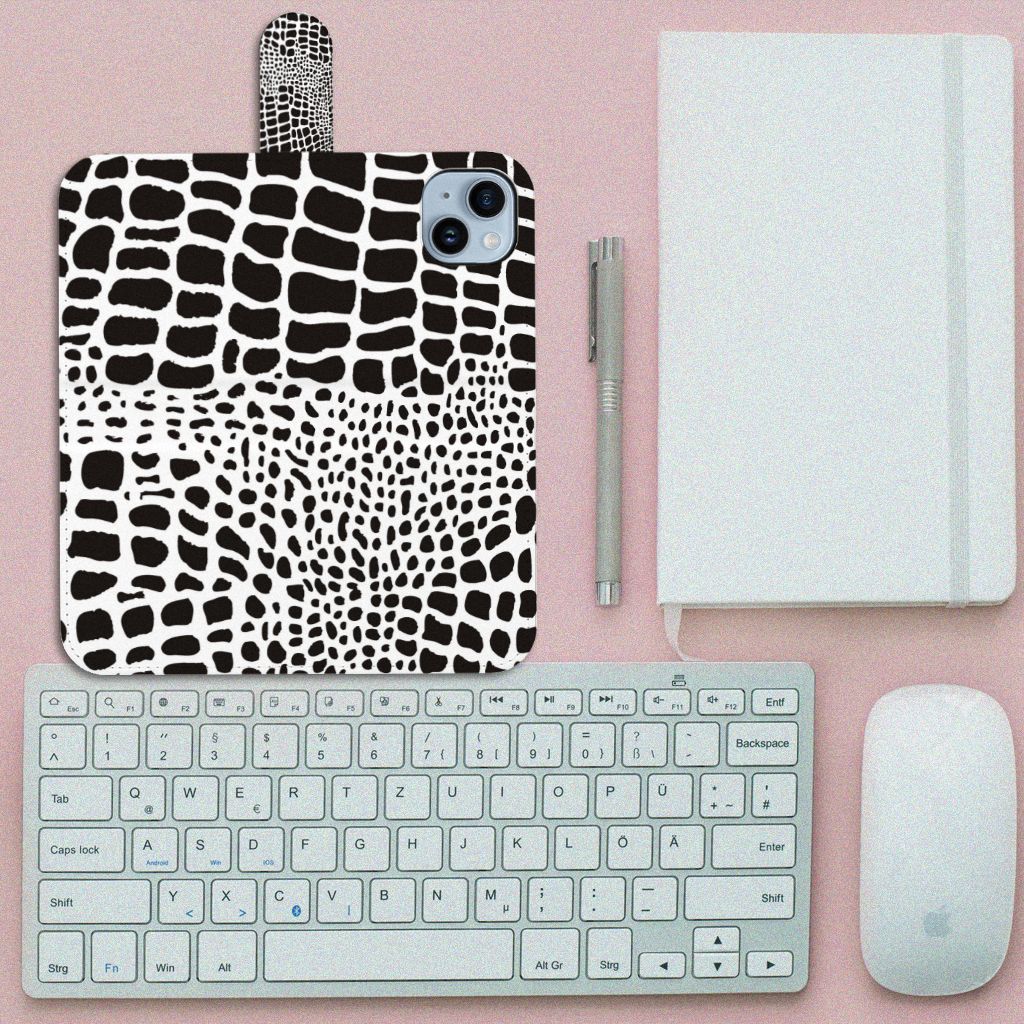 iPhone 15 Plus Telefoonhoesje met Pasjes Slangenprint op een bureau met toetsenbord en notitieboekje.