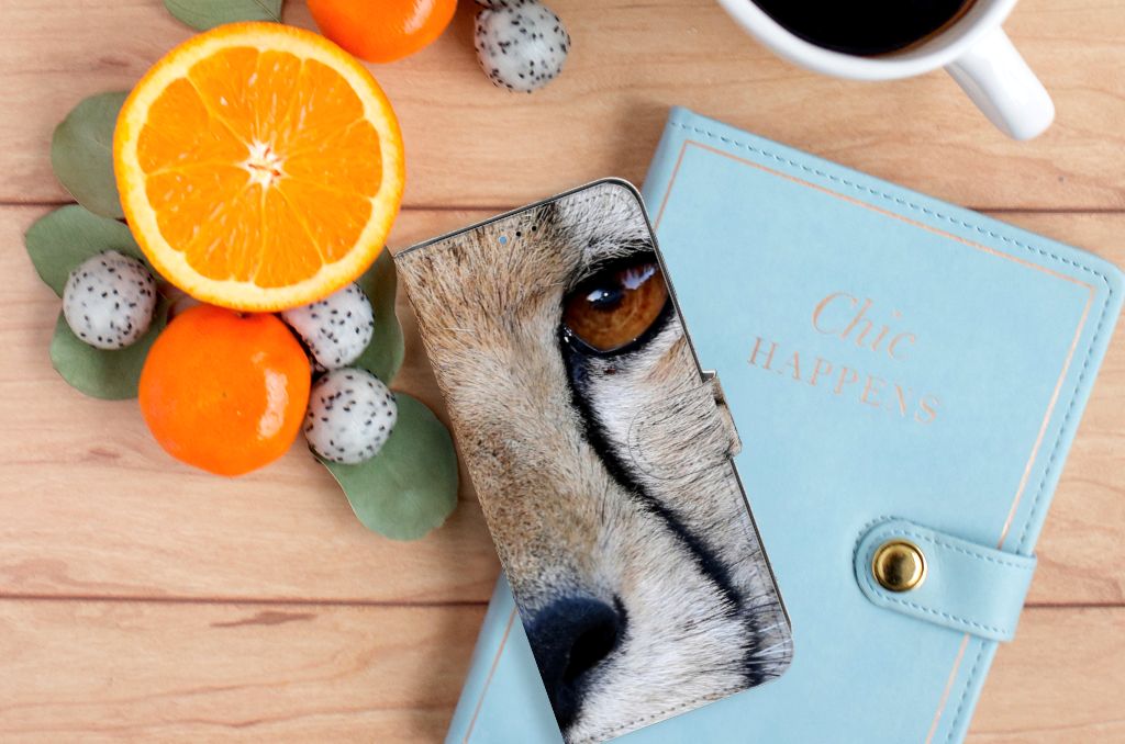 Motorola Moto E20 | E30 | E40 Telefoonhoesje met Pasjes Cheetah met close-up van een cheeta oog op een houten tafel.