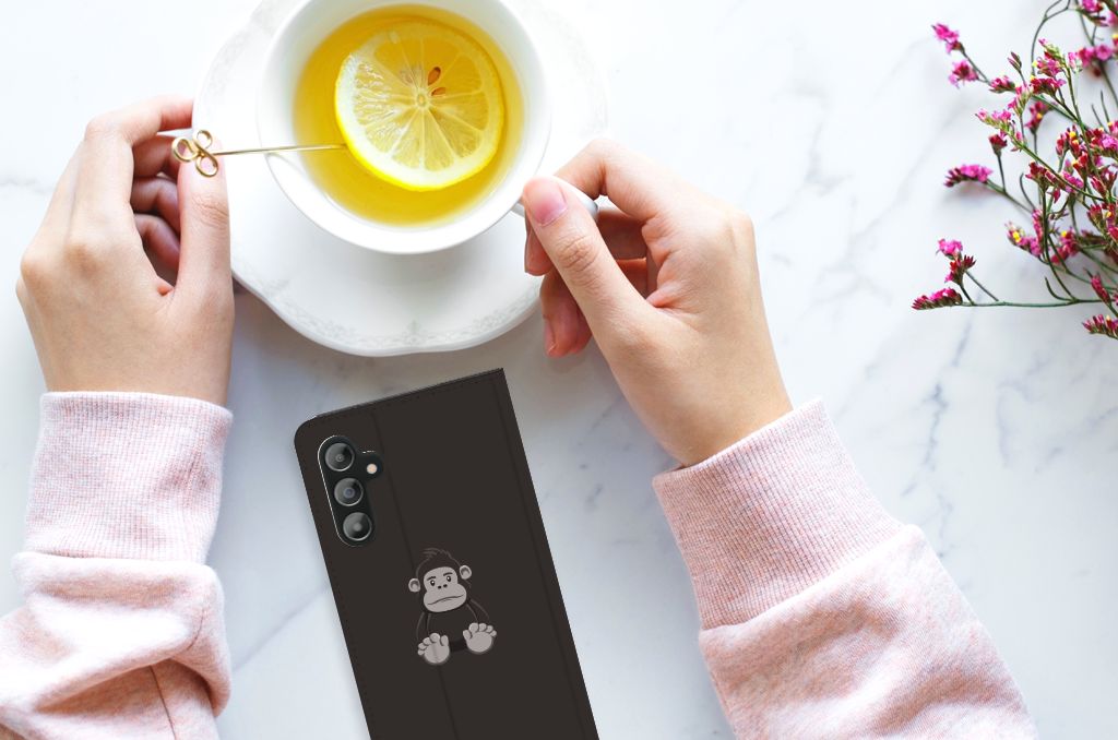Samsung Galaxy A14 4G Magnet Case Gorilla op tafel met hand en kopje thee.