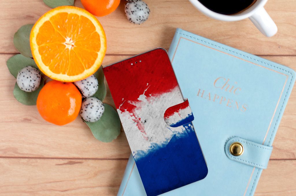 OPPO A17 Bookstyle Case Nederland met Nederlandse vlag op een houten tafel met fruit en een notitieboek.