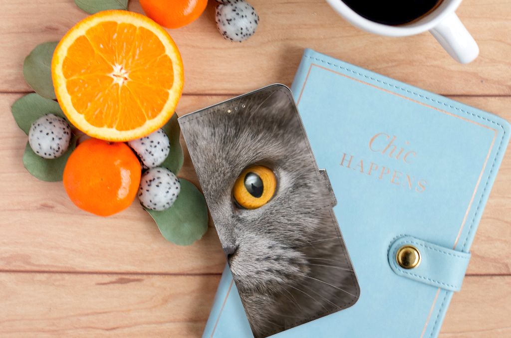 Telefoonhoesje met Pasjes OPPO A15 Britse Korthaar met kattenoogdesign op een houten tafel met fruit en notebook.