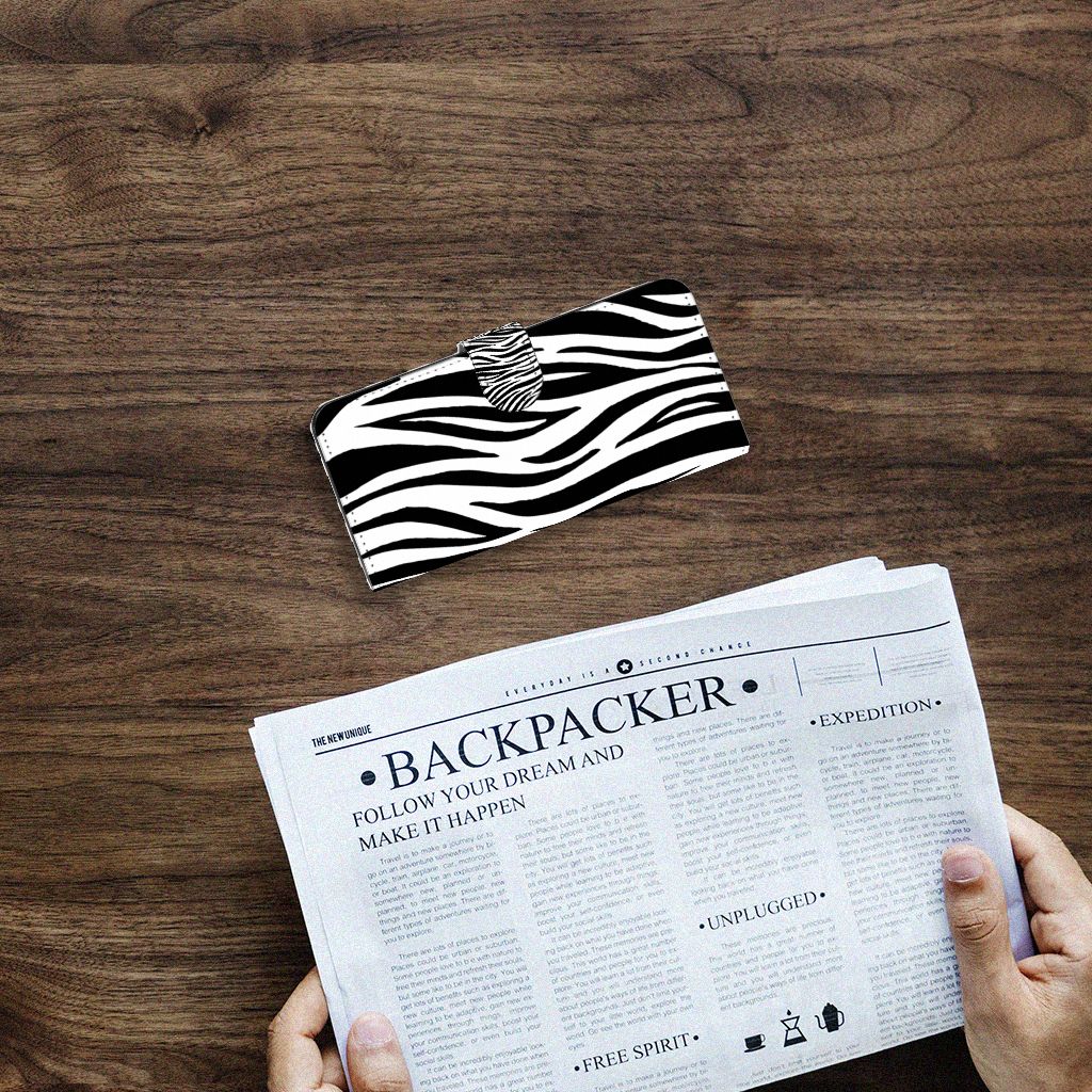 Samsung Galaxy A14 4G Telefoonhoesje met Pasjes Zebra op een houten tafel met een krant.