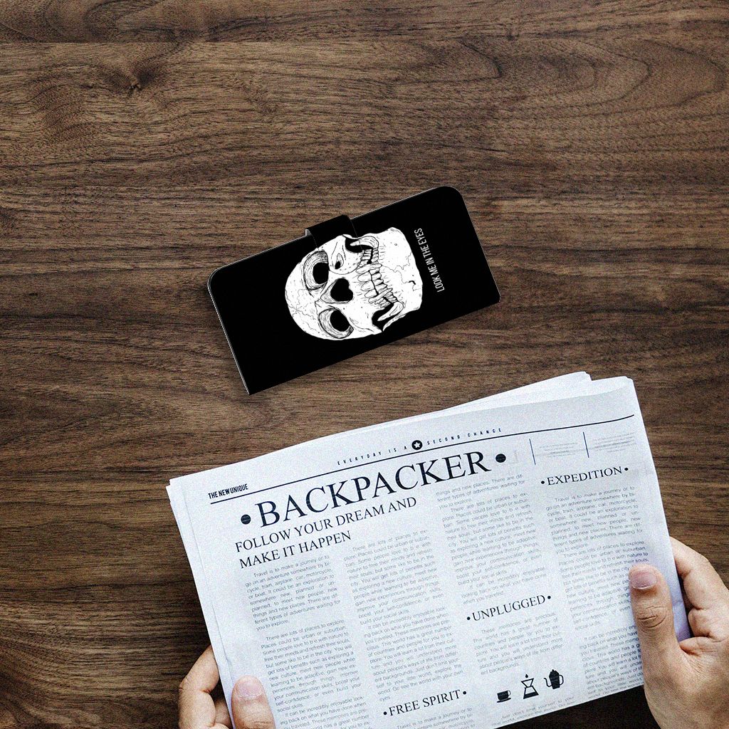 Telefoonhoesje met Naam Samsung Galaxy A14 4G Skull Eyes op een tafel met een krant eronder.