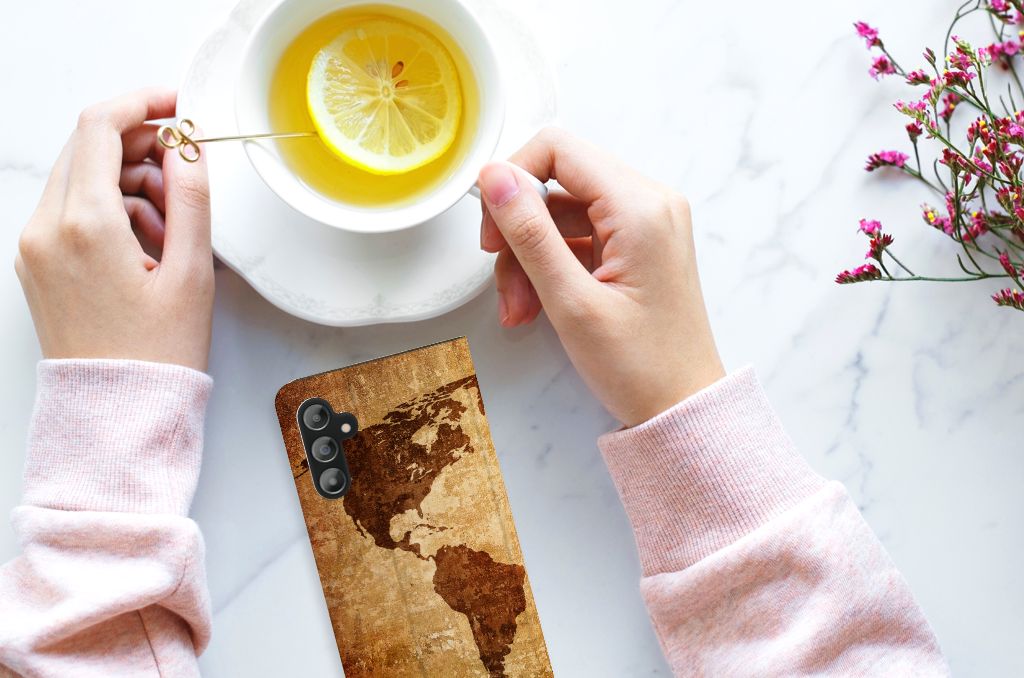 Samsung Galaxy A14 5G Book Cover Wereldkaart met een wereldkaart design naast een kopje thee.