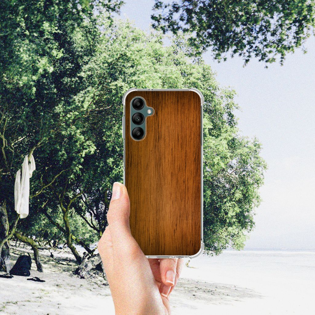 Samsung Galaxy A14 5G/4G Stevig Telefoonhoesje Donker Hout in gebruik met natuurlijke achtergrond.