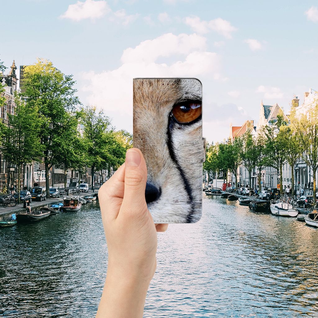 OnePlus Nord 2 5G Telefoonhoesje met Pasjes Cheetah in een hand met Amsterdamse grachten op de achtergrond.