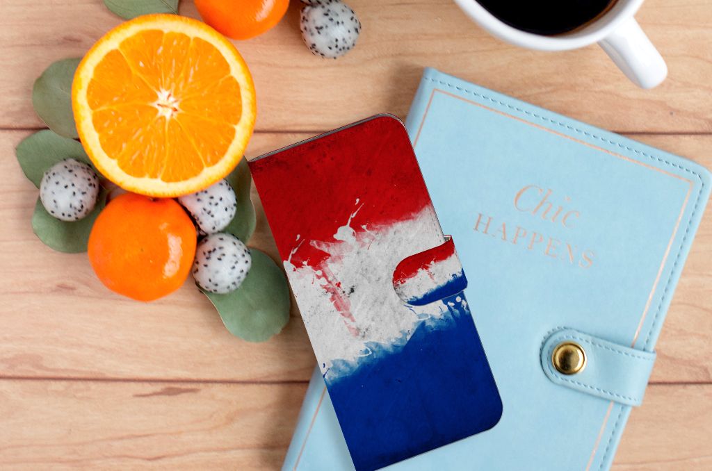 Motorola Edge 20 Lite Bookstyle Case Nederland met artistiek ontwerp van de Nederlandse vlag op een houten tafel met fruit.