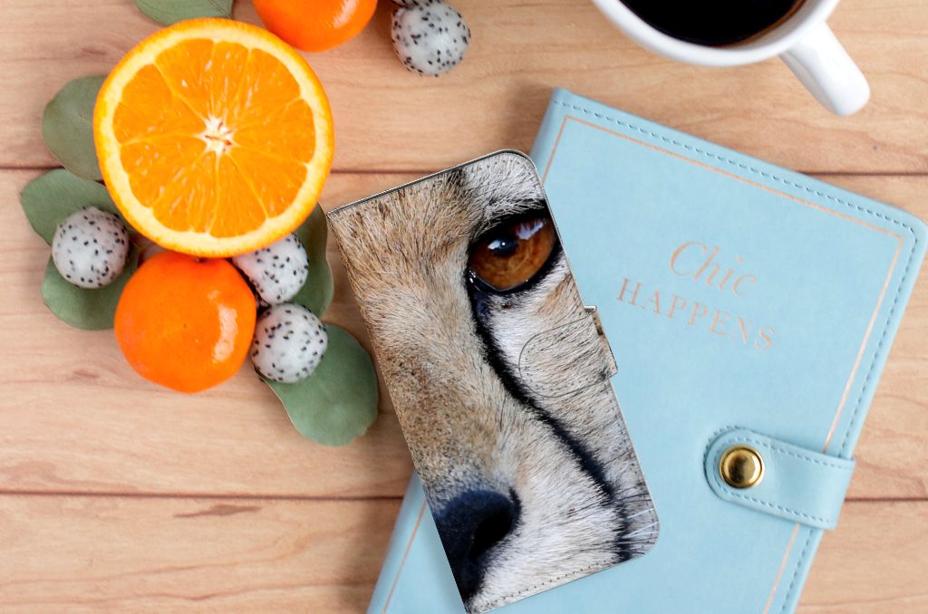 OnePlus 11 Telefoonhoesje met Pasjes Cheetah met close-up van cheeta oog op een bureau met fruit en notitieboekje.