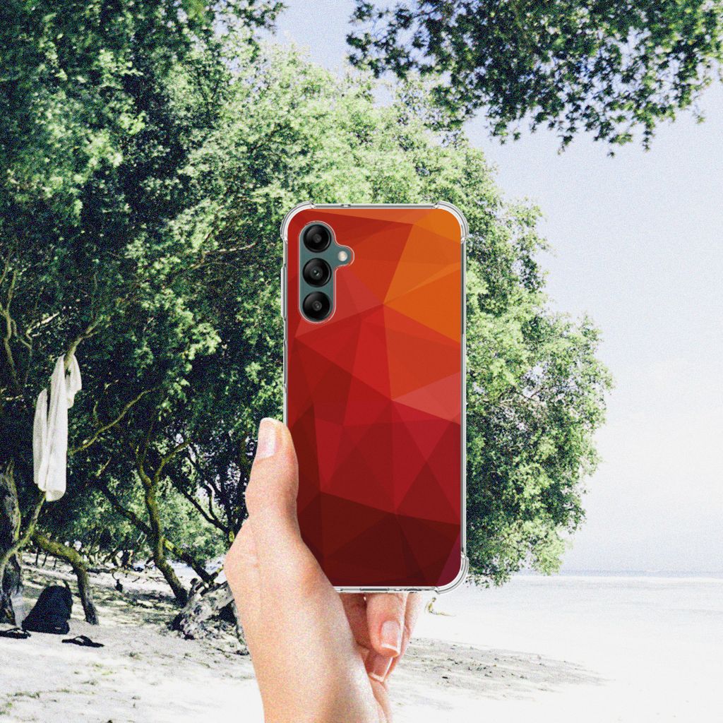 Shockproof Case voor Samsung Galaxy A14 5G/4G Polygon Red in een hand op het strand met groene bomen op de achtergrond.