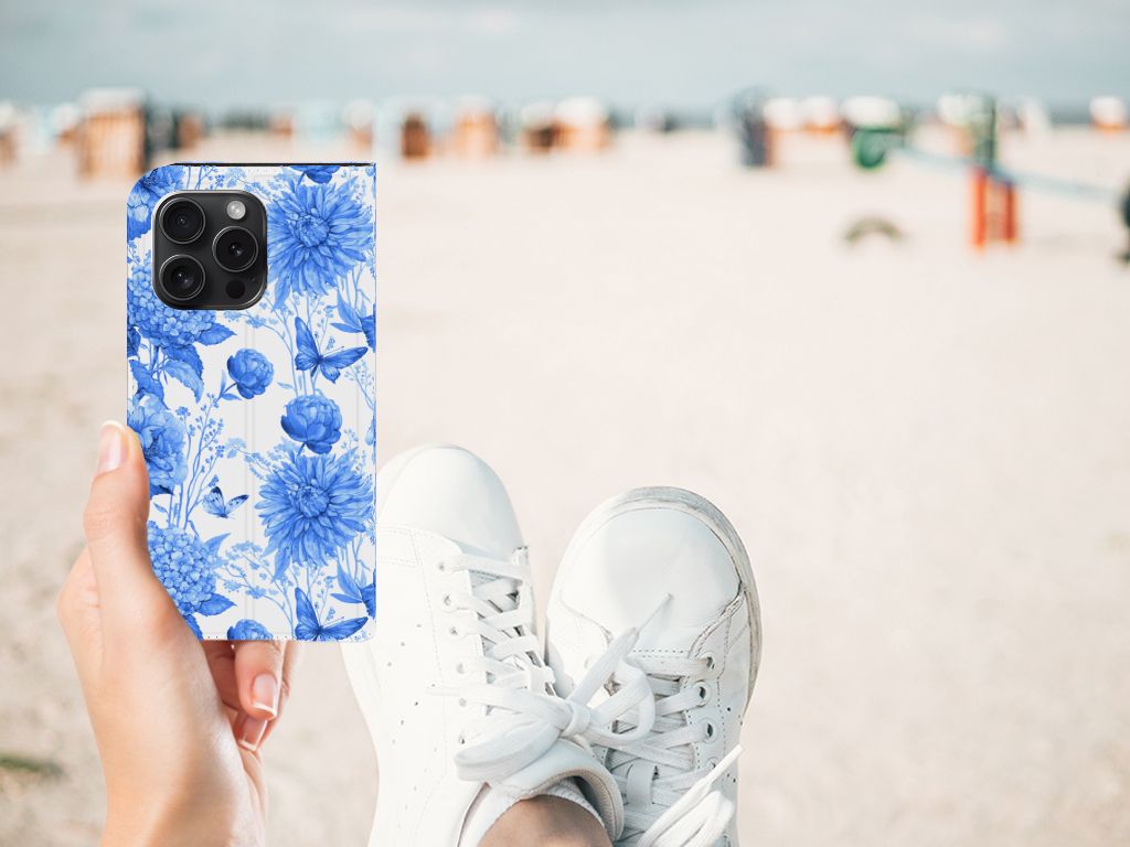 Smart Cover voor iPhone 15 Pro Flowers Blue in handen op het strand, met een trendy bloemenontwerp đ¸.