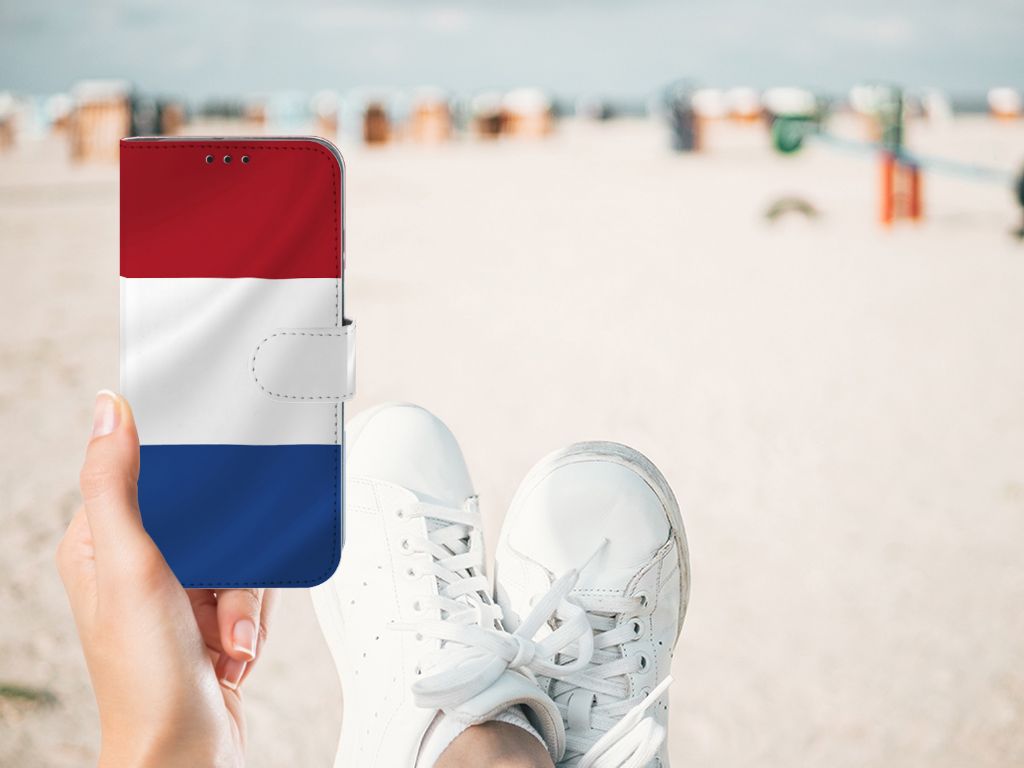 Honor 10 Lite Bookstyle Case Nederlandse Vlag in hand met witte sneakers op het strand.